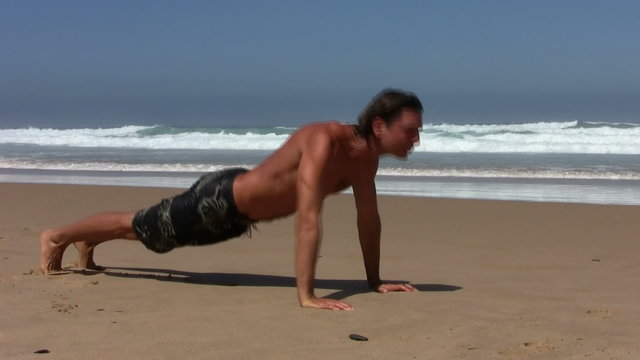 Young guy doing push-ups at the beach