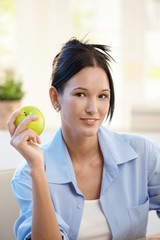 Portrait of young woman with apple