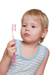 child looks at the toothbrush