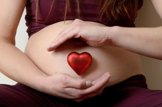 Donna in gravidanza con cuore rosso