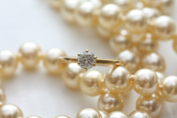 Diamond solitaire engagement ring on pearl necklace