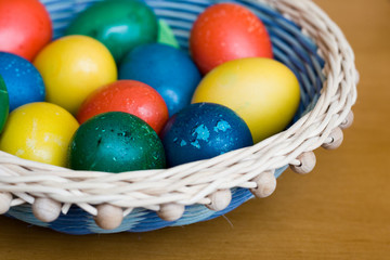 Fototapeta na wymiar Wicker basket with handmade coloured Easter eggs