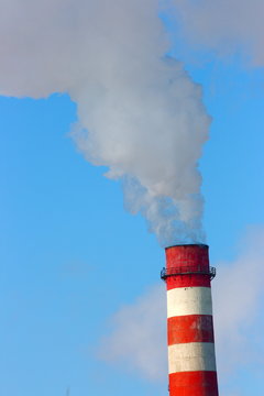 Smoking stack of the thermal power station against a blue sky