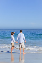 Fototapeta na wymiar Couple walking on the beach under the sun