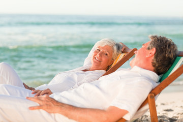 Obraz premium Elderly couple relaxing in their deck chairs