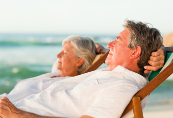 Fototapeta premium Elderly couple relaxing in their deck chairs