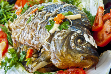 fried fish with fresh herbs, tomatoes.