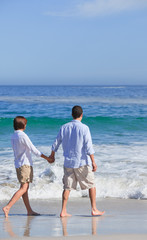 Couple walking on the beach under the sun