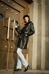 Beautiful young woman near the bronze doors