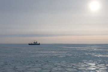 Ship in the middle of the ice field at sunset