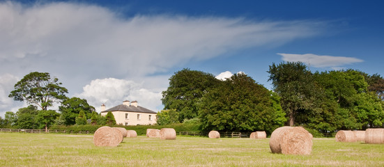 scenic irish cottage on a farm with hay field