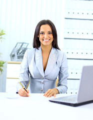 Young happy smiling businesswoman working at office