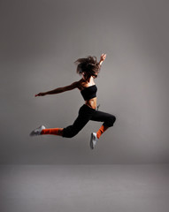 Fototapeta na wymiar A young brunette dancer is caught in a beautiful jump