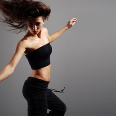 A young brunette dancer is caught in a beautiful jump