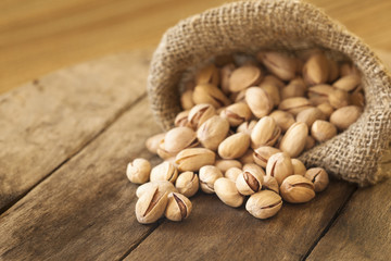 Roasted pistachios on natural wooden table background