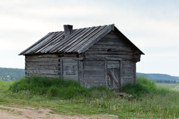 Деревянный сарай на высоком берегу реки.