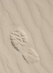 Sport footwear print on light sand with diagonal pattern