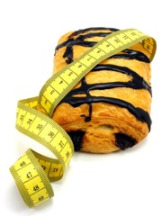 Chocolate pastry cake & measuring tape in diet concept