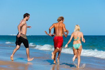 Freunde laufen im Urlaub am Strand