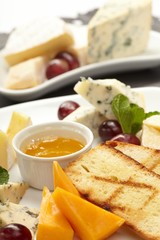 Cheese plate with grapes and honey