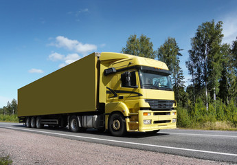 Fototapeta na wymiar yellow truck speeding on country road