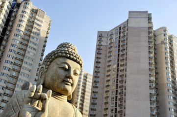Fototapeta na wymiar Buddha in front of apartment buildings