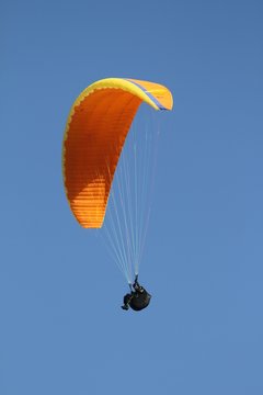 parapente orange sur fond de ciel bleu