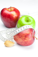 apple, nuts and measure tape isolated on white