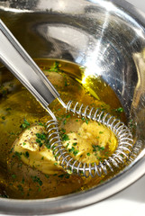 Vinaigrette ingredients in a metal bowl with a whisk
