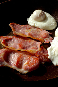 Three fried bacon rashers with a poached egg