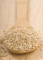 Steel cut oats on a wooden spoon