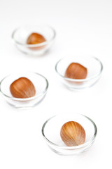 Nuts in miniature glass bowls isolated on white