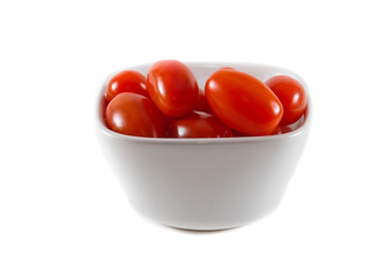 A bowl of red cherry tomatoes on an isolated background