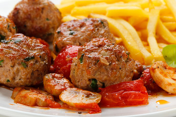Roasted meatballs, French fries and vegetables