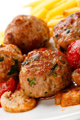 Roasted meatballs, French fries and vegetables