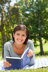 Fototapeta premium Woman reading a book in the park