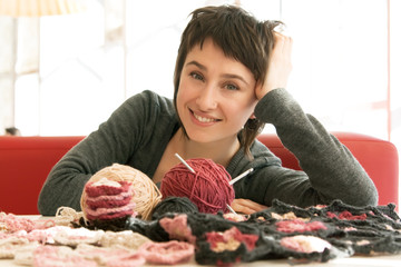 Portrait of a young beautiful girl with knitting