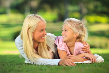 Mother with her daughter lying down in the park