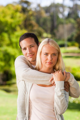 Obraz premium Woman hugging her boyfriend in the park