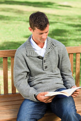 Fototapeta premium Man reading his book on the bench