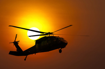 Fototapeta na wymiar Lądowanie śmigłowca na zachodzie słońca