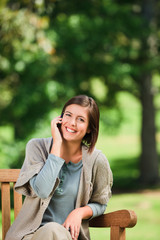 Beautiful woman phoning on the bench