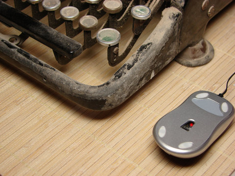 Old dark typewriter with modern mouse