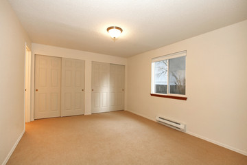 Empty white bedroom with one window and closet