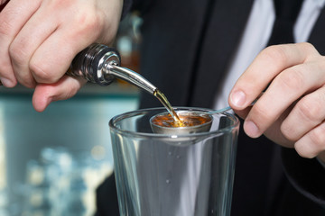 Fototapeta na wymiar Bartender pouring alcohol in measuring spoon