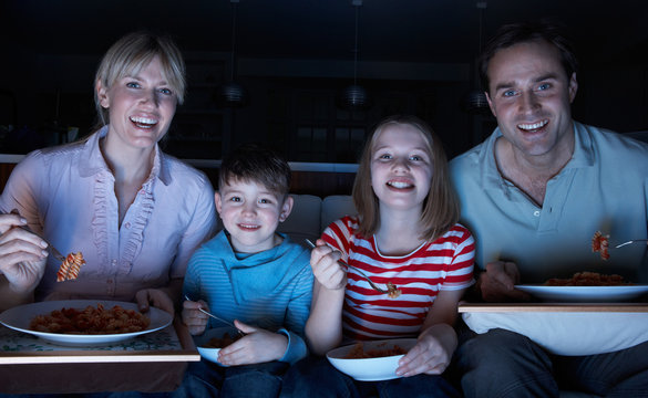 Family Enjoying Meal Whilst Watching TV