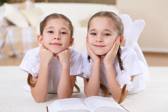 twin sisters together at home with books