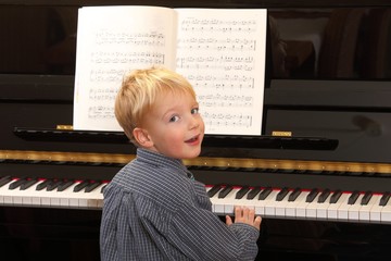 Kleiner Junge spielt Klavier