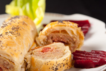 Roll of spicy sausage in flaky pastry
