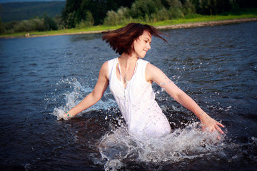 Young beautiful  woman on a river